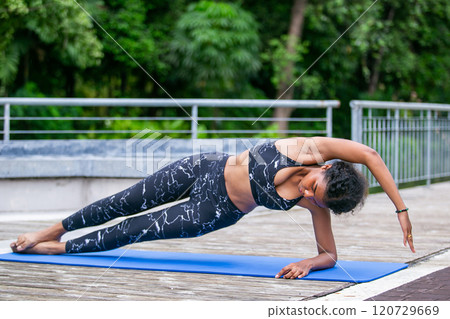 Sporty fit american african women sportswear performing asana yoga, Pose Outdoor active workout. Strong female healthy lifestyle. Relax yoga exercise concept. Sporty fit american african women sportswear performing asana yoga, Pose Outdoor active workout. Strong female healthy lifestyle. Relax yoga exercise concept. 120729669