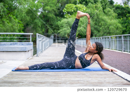 Sporty fit american african women sportswear performing asana yoga, Pose Outdoor active workout. Strong female healthy lifestyle. Relax yoga exercise concept. Sporty fit american african women sportswear performing asana yoga, Pose Outdoor active workout. Strong female healthy lifestyle. Relax yoga exercise concept. 120729670