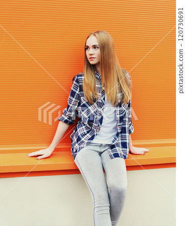 Fashion pretty blonde girl in city over colorful orange background 120730691