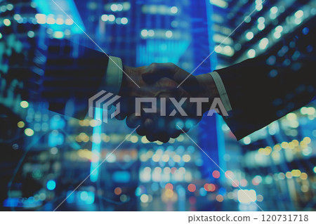 Corporate handshake, global tech graphics blurred behind 120731718
