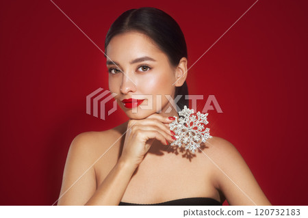 Beautiful young woman with glowing snowflake 120732183
