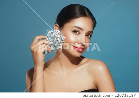Beautiful young woman with glowing snowflake 120732187
