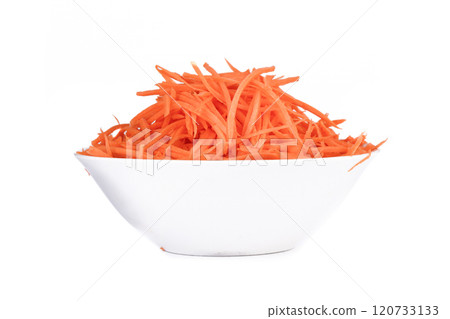 Carrots cut into thin strips as an ingredient for different dishes in a bowl on a white background. Carrots cut into thin strips as an ingredient for different dishes in a bowl on a white background. 120733133