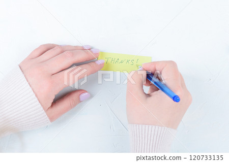 A young woman creates a handwritten Thanks note. 120733135