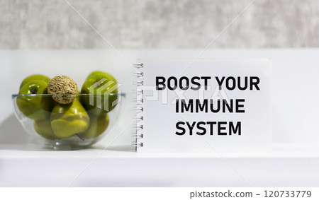 A vase with apples and nuts and a notepad with text Strengthen your immune system A vase with apples and nuts and a notepad with text Strengthen your immune system 120733779