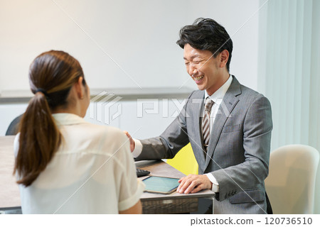 一個穿西裝的男人和一個女人說話 120736510