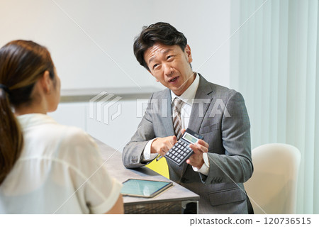 一個穿西裝的男人和一個女人說話 120736515