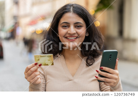 Indian woman using credit bank card smartphone while transferring money purchases online shopping Indian woman using credit bank card smartphone while transferring money purchases online shopping 120736749