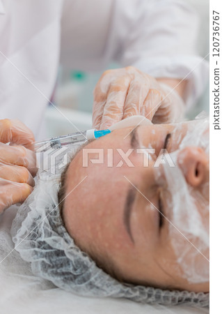 Cosmetologist making woman beauty anti-aging injections biorevitalization face forehead mesotherapy Cosmetologist making woman beauty anti-aging injections biorevitalization face forehead mesotherapy 120736767