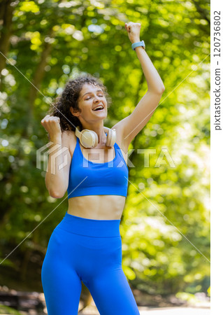 Athletic fit runner girl celebrate success win scream rejoices triumph victory marathon race in park Athletic fit runner girl celebrate success win scream rejoices triumph victory marathon race in park 120736802