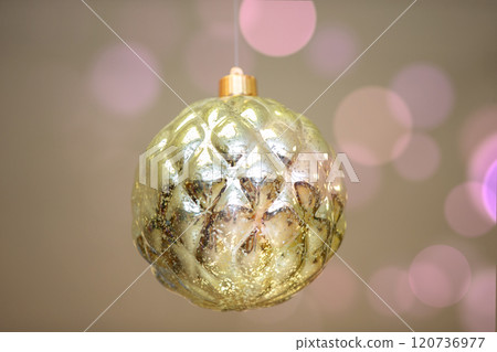 Golden toy Christmas ball on a background of pink bokeh spots. 120736977