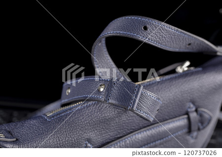 Part of a blue leather bag on a black background. Leather goods. Part of a blue leather bag on a black background. Leather goods. 120737026