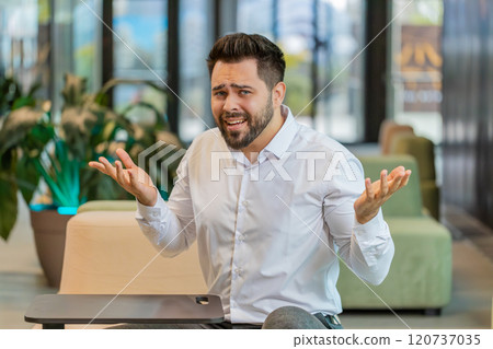 Angry businessman raising hands in indignant expression, asking reason of failure in office lobby Angry businessman raising hands in indignant expression, asking reason of failure in office lobby 120737035