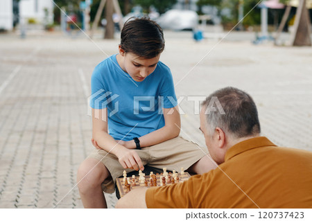 Boy Learning To Play Chess With Grandfather Boy Learning To Play Chess With Grandfather 120737423