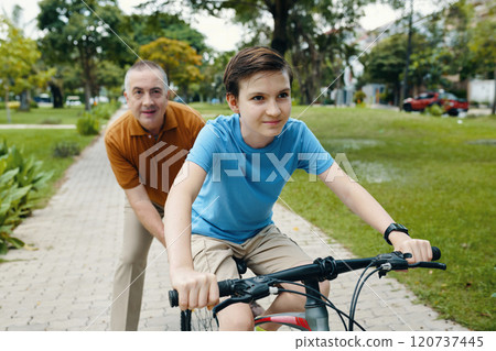 Boy Riding A Bike In The Park Boy Riding A Bike In The Park 120737445