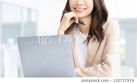 Smiling business woman using a computer Smiling business woman using a computer 120737919