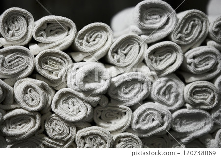 Stacked white towels neatly arranged in a bathroom setting 120738069