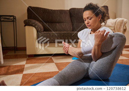 Woman practicing yoga at home in comfortable living room setting Woman practicing yoga at home in comfortable living room setting 120738612