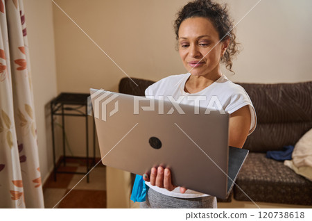 Woman using laptop at home for remote work session Woman using laptop at home for remote work session 120738618