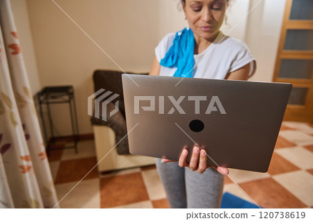 Woman using laptop for online workout at home Woman using laptop for online workout at home 120738619