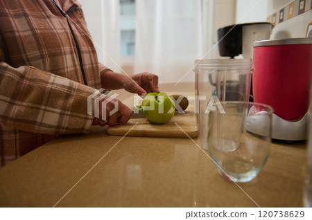 Woman preparing a healthy smoothie with fresh apple and kiwi 120738629