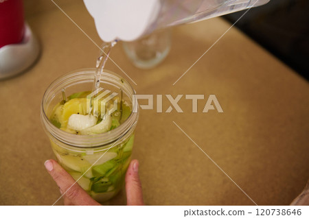 Pouring water into a blender for fresh vegetable smoothie Pouring water into a blender for fresh vegetable smoothie 120738646
