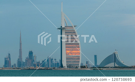 Dubai skyline with Burj Al Arab hotel during sunset and day to night timelapse. Dubai skyline with Burj Al Arab hotel during sunset and day to night timelapse. 120738693