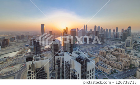 Aerial view of a big modern city with sunset timelapse. Business bay, Dubai, United Arab Emirates. 120738713