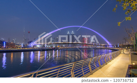 Pedestrian Bridge over the Dubai Water Canal day to night timelapse, United Arab Emirates 120738752