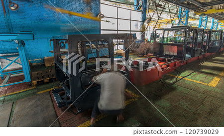 Conveyor assembly stage the body of tractor at big industrial factory timelapse Conveyor assembly stage the body of tractor at big industrial factory timelapse 120739029