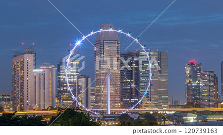 Skyline of Singapore with famous Singapore Ferries Wheel night to day timelapse Skyline of Singapore with famous Singapore Ferries Wheel night to day timelapse 120739163
