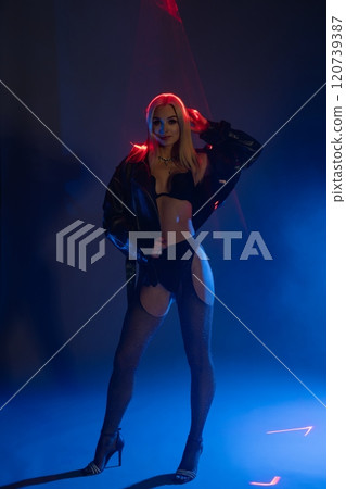 Stylish model poses with confidence in dramatic lighting at night Stylish model poses with confidence in dramatic lighting at night 120739387
