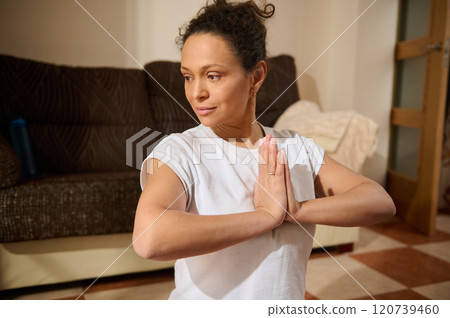 Woman practicing yoga meditation in cozy home setting Woman practicing yoga meditation in cozy home setting 120739460