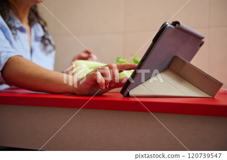 Woman using tablet in the kitchen for cooking assistance Woman using tablet in the kitchen for cooking assistance 120739547