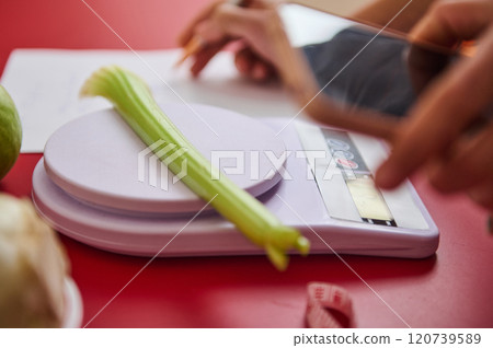 Celery on digital scale with focus on healthy eating Celery on digital scale with focus on healthy eating 120739589
