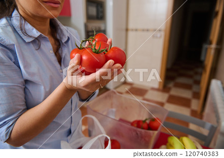 Woman holding fresh tomatoes in a cozy kitchen setting Woman holding fresh tomatoes in a cozy kitchen setting 120740383