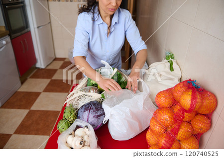Woman organizing fresh groceries in home kitchen setting 120740525