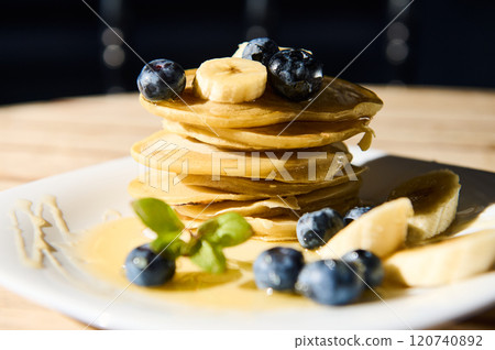 Delicious stack of pancakes with fresh blueberries and bananas 120740892
