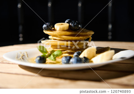Delicious pancakes stack with blueberries and bananas on plate 120740893