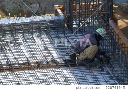 Reinforcement workers at work at a new apartment building construction site 120741645