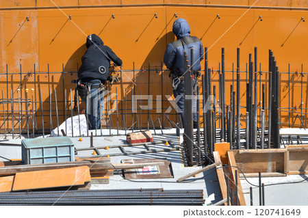 Reinforcement workers at work at a new apartment building construction site 120741649