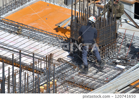 Reinforcement workers at work at a new apartment building construction site 120741650