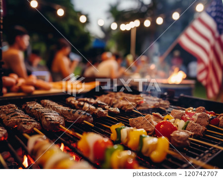 Close-up of Grilled Skewers with Blurred Background of People and an American Flag 120742707