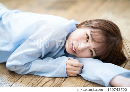 Young woman lying on flooring Young woman lying on flooring 120743700