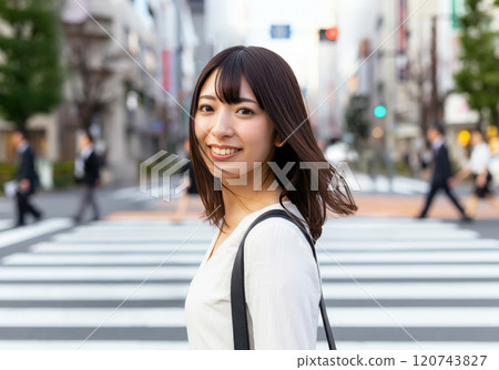 一位年輕女子走在十字路口時微笑著看著我 一位年輕女子走在十字路口時微笑著看著我 120743827