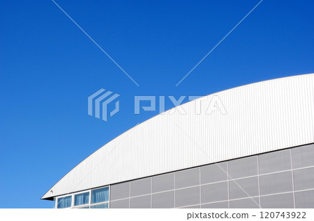 A facility with a distinctive roof and blue skies 120743922