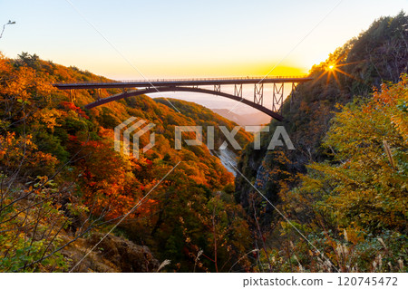 Fukushima City, Fukushima Prefecture: The Bandai-Azuma Skyline, which connects Takayu Onsen and Tsuchiyu Pass, and the autumn leaves and morning sun at Tsubakurodani Fudosawa Bridge in the morning glow 120745472