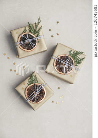 Gifts boxes in golden paper with dry oranges 120745683