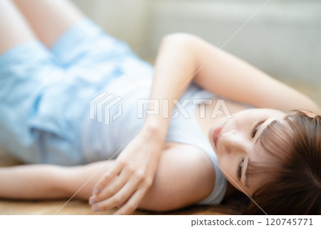 Young woman lying on flooring Young woman lying on flooring 120745771