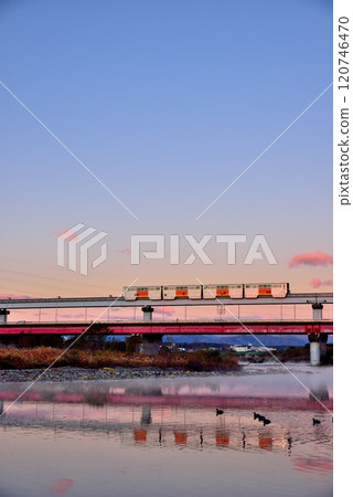 A clear morning sky and the Tama Monorail reflected on the river surface 120746470